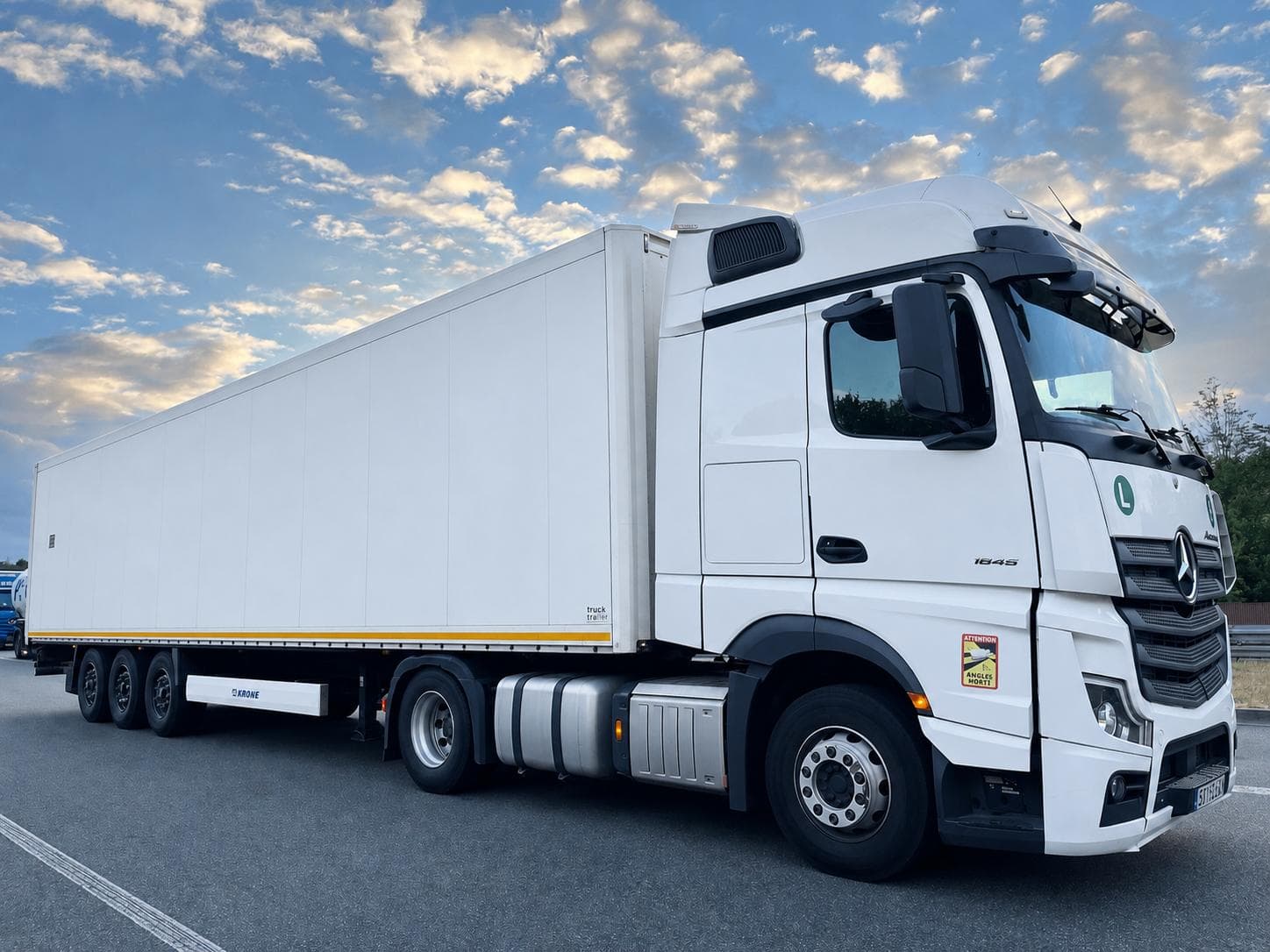 White Mercedes-Benz Actros 1845 with a Krone curtain-side trailer