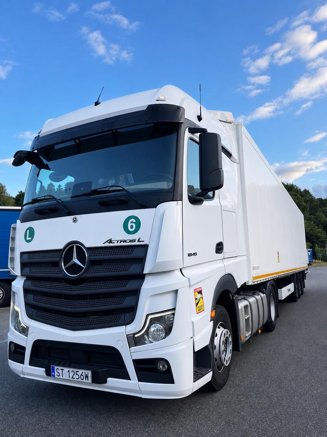 White Mercedes-Benz Actros L 1845 with a box trailer under a blue sky