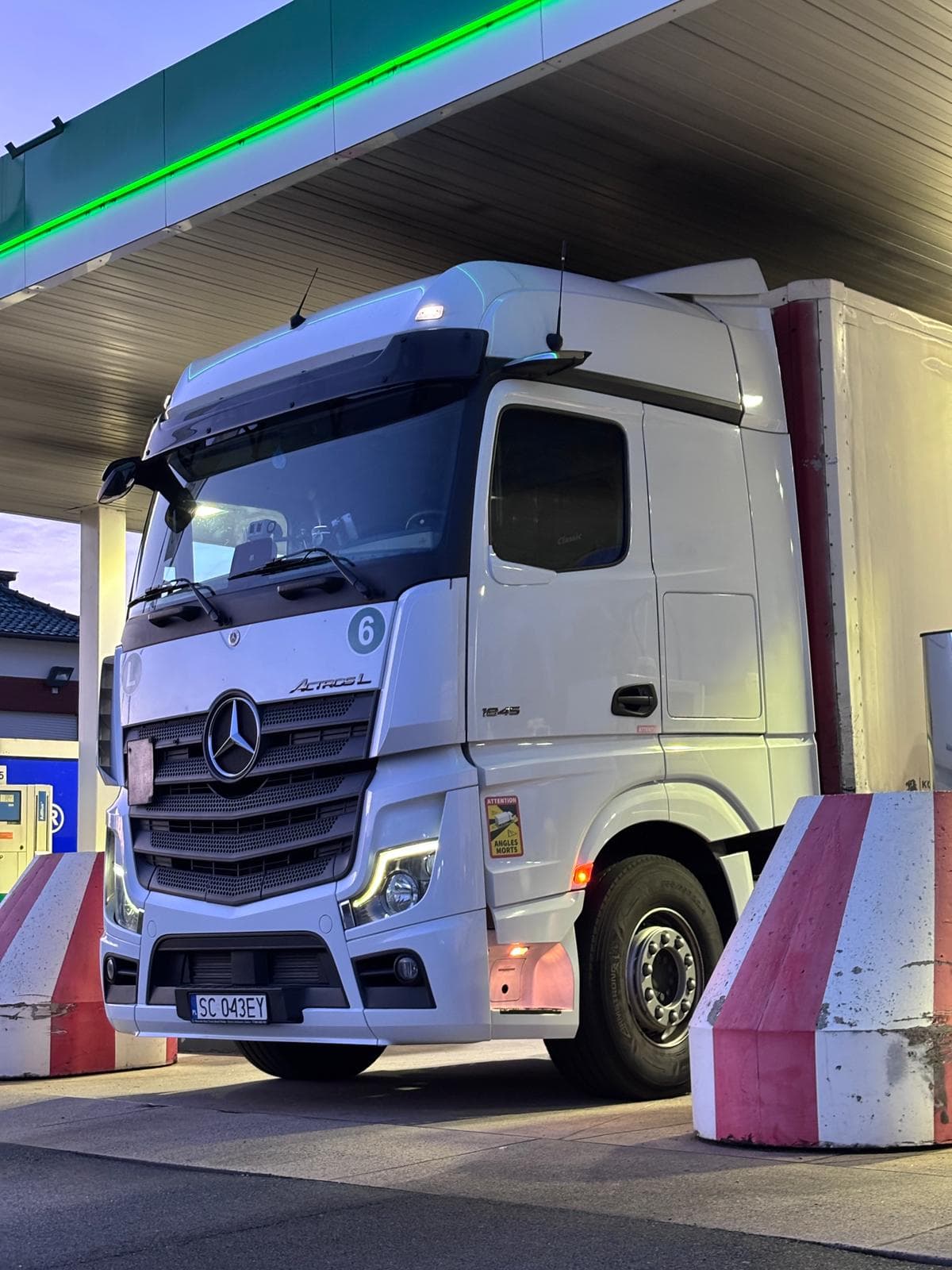 White Mercedes-Benz Actros L 1845 refuelling under a station canopy